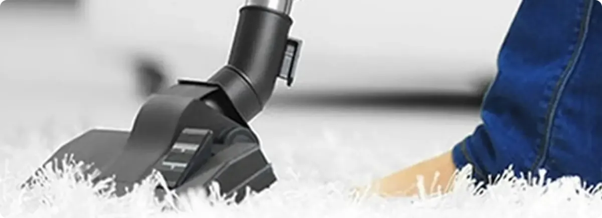 Close-up of a professional vacuuming a white carpet in Whitmore Lake.